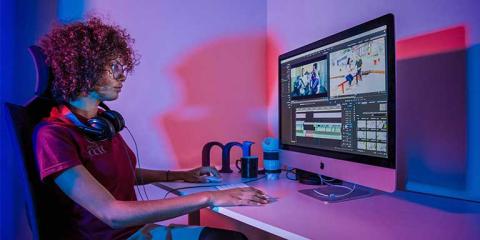 Student working at a computer using Premiere Pro on a video editing project as part of a training class.